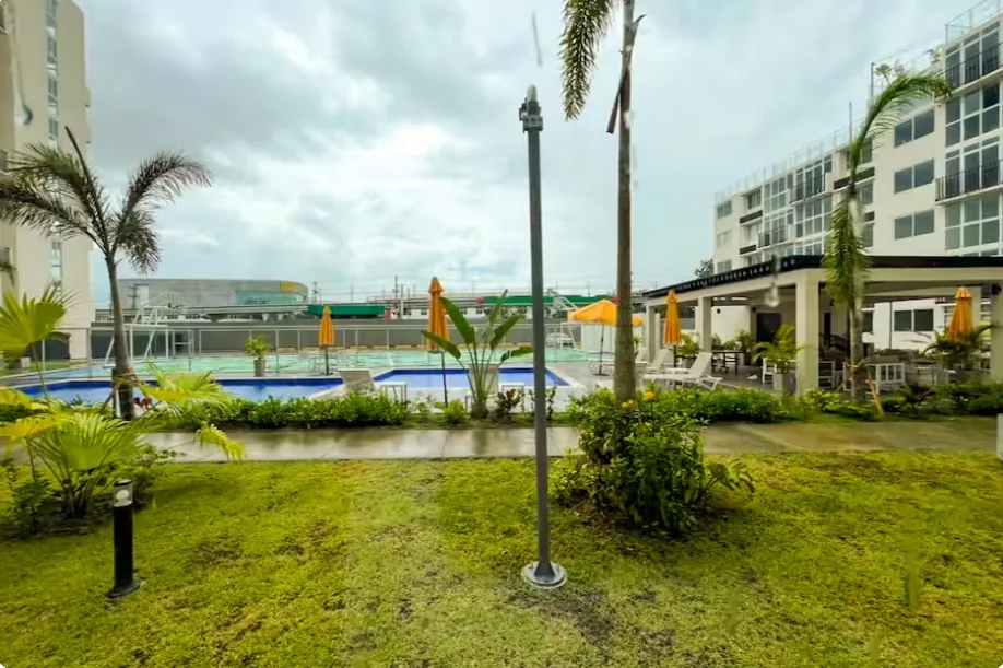Outdoor swimming pool with sun loungers and palm trees near Tocumen Airport