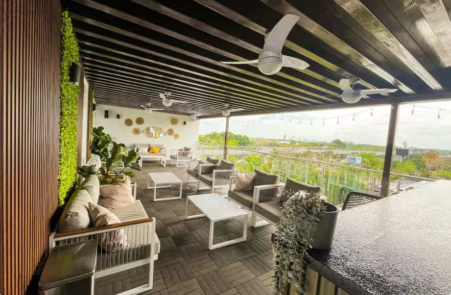 Rooftop lounge with green living wall and panoramic city view near Tocumen